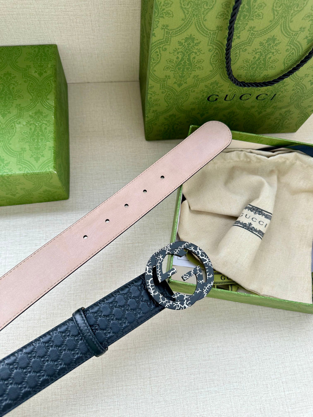 Dark blue leather belt with light pink underside strap and silver logo buckle