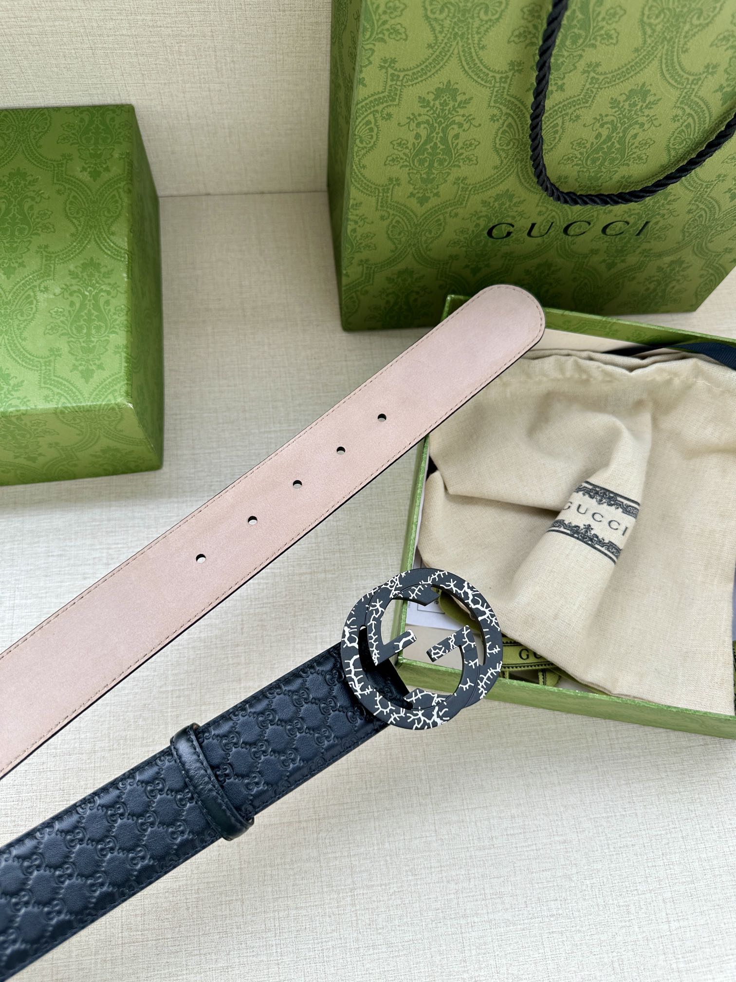 Dark blue leather belt with light pink underside strap and silver logo buckle