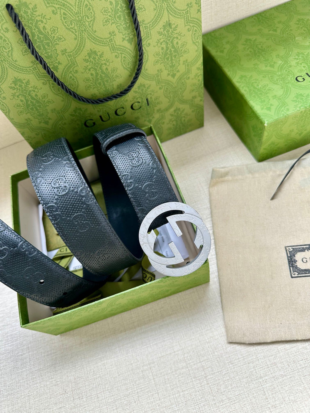 Gucci belt straps in box, showing textured dark blue leather and buckle