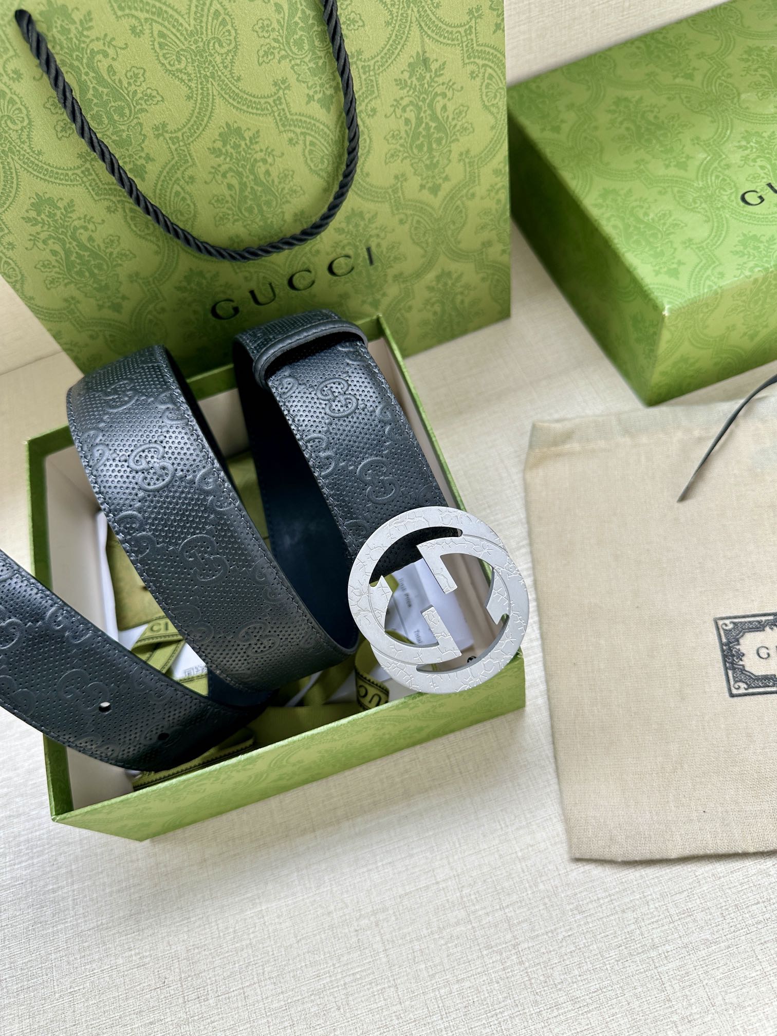 Gucci belt straps in box, showing textured dark blue leather and buckle