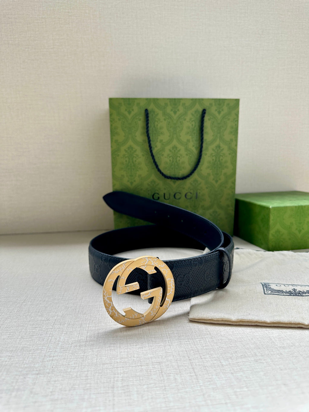 Dark blue Gucci belt with gold-toned logo buckle and dust bag