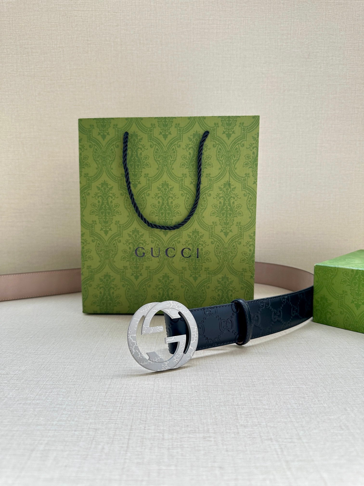 Gucci belt front view: dark navy GG embossed strap with silver-tone interlocking G buckle