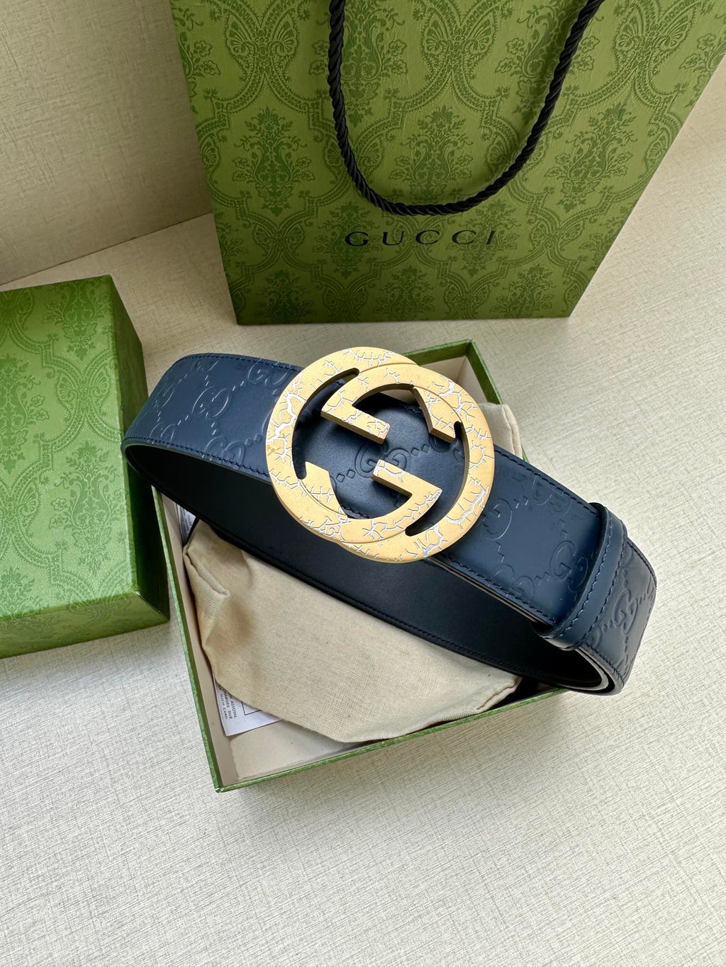Gucci belt with dark blue strap and gold-tone GG buckle
