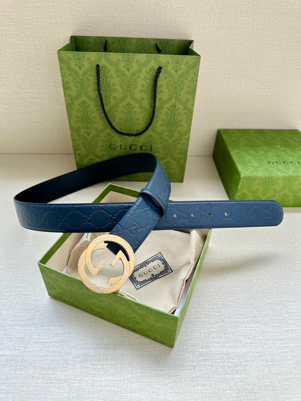 Gucci belt with dark blue leather strap and gold-tone round GG buckle