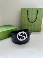 Gucci belt with dark blue leather and embossed pattern, featuring a silver-toned logo buckle
