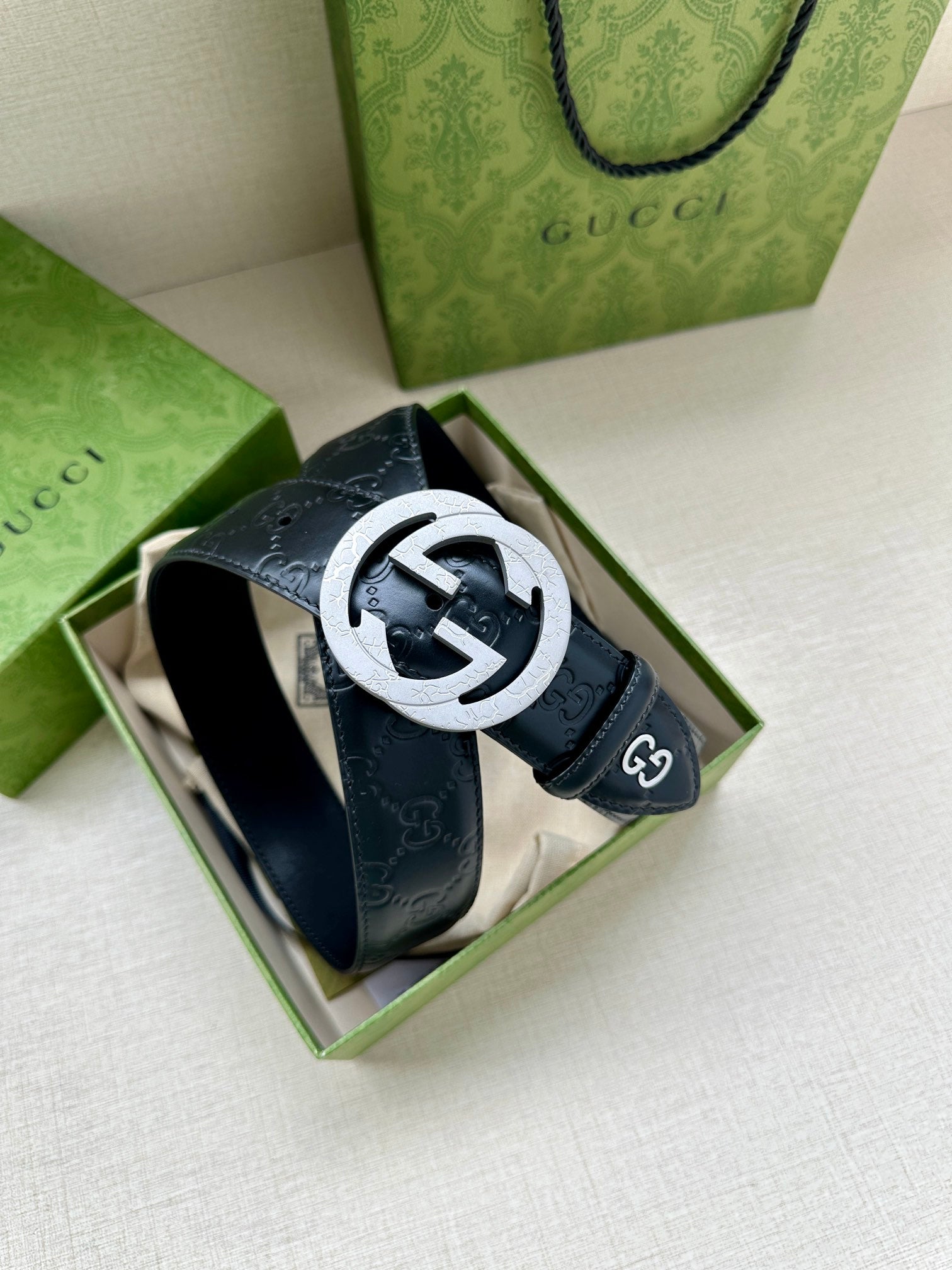 Gucci belt in a gift box, dark blue embossed leather with a large round logo buckle