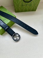 Gucci belt strap close-up, dark blue embossed leather with a silver logo buckle