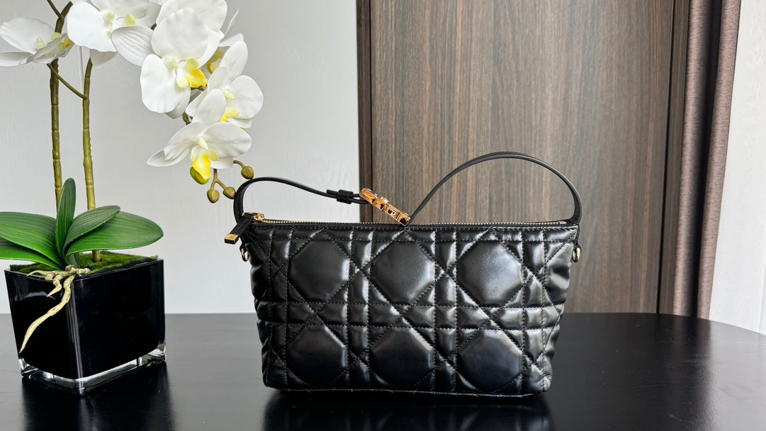 Dior quilted handbag in black with gold-tone top handle and zipper detail