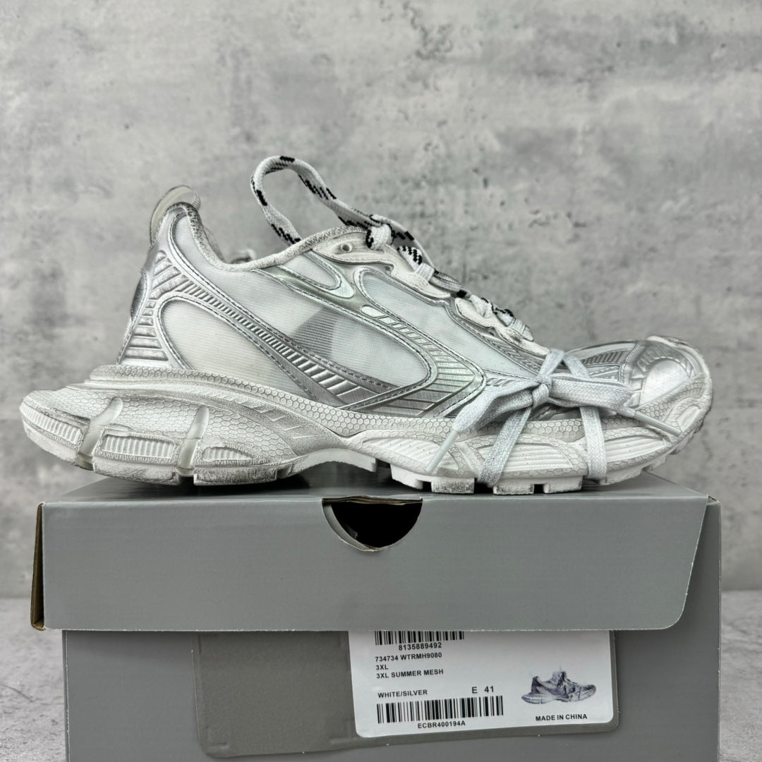 Balenciaga silver lace-up sneakers on a box, side view