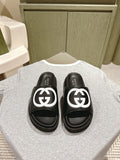 Black slide sandals with white GG logo straps and cushioned footbeds