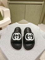 Black slide sandals with white GG logo straps and cushioned footbeds