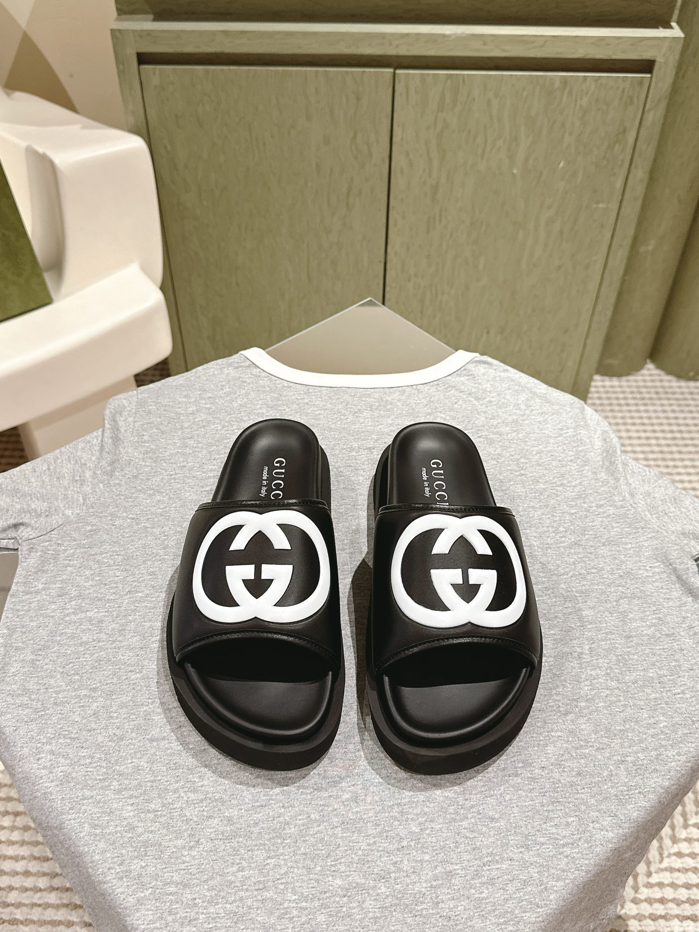 Black slide sandals with white GG logo straps and cushioned footbeds