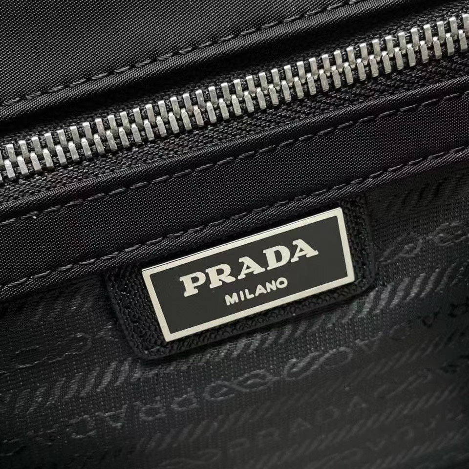 Prada Milano label on black bag zipper tape with silver teeth and stitched trim.