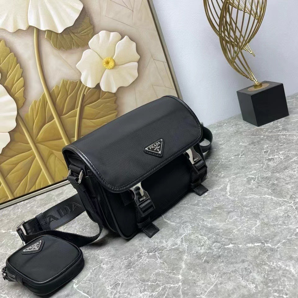 Prada black leather crossbody bag with flap, front logo patch, and mini pouch.