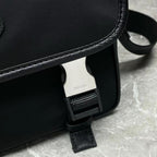 Prada black bag corner with adjustable strap buckle and interior tag visible.