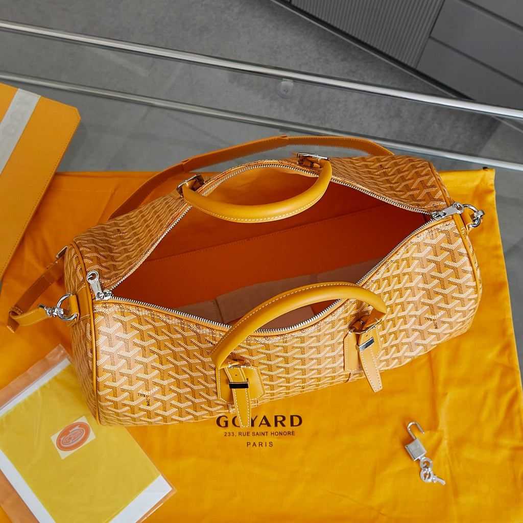 Goyard duffel bag with yellow patterned body, top zipper, adjustable shoulder strap