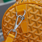 Yellow leather strap detail with metal hook hardware on patterned bag