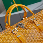 Yellow leather top handles and strap hardware on patterned duffel bag