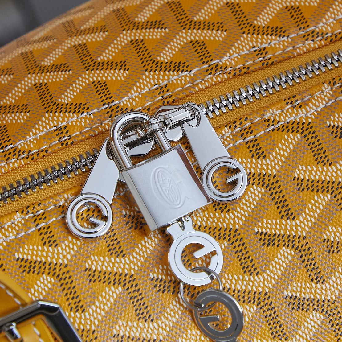 Metal zipper pull and lock hardware on yellow patterned duffel bag