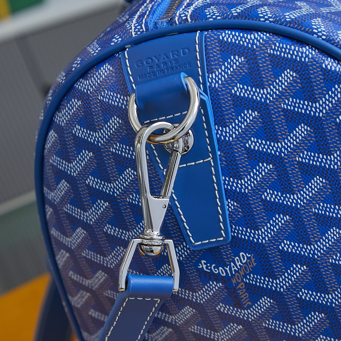 Goyard blue monogram duffle bag close-up: top handle and metal clip