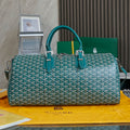 Goyard bag in teal with white Goyard pattern, top handles and shoulder strap