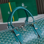 Goyard bag with teal handles and teal leather straps, silver hardware on logo canvas