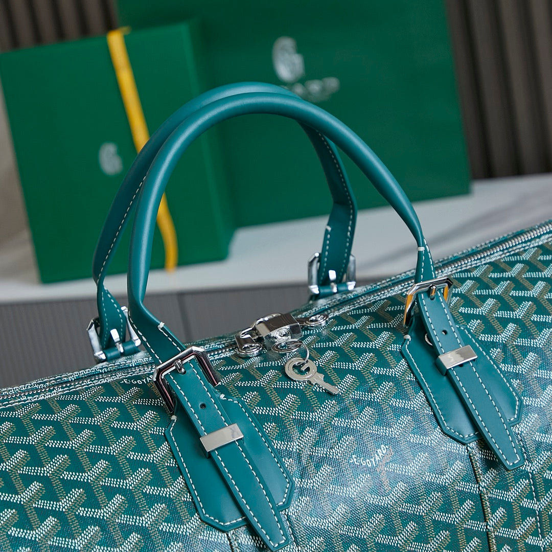Goyard bag with teal handles and teal leather straps, silver hardware on logo canvas