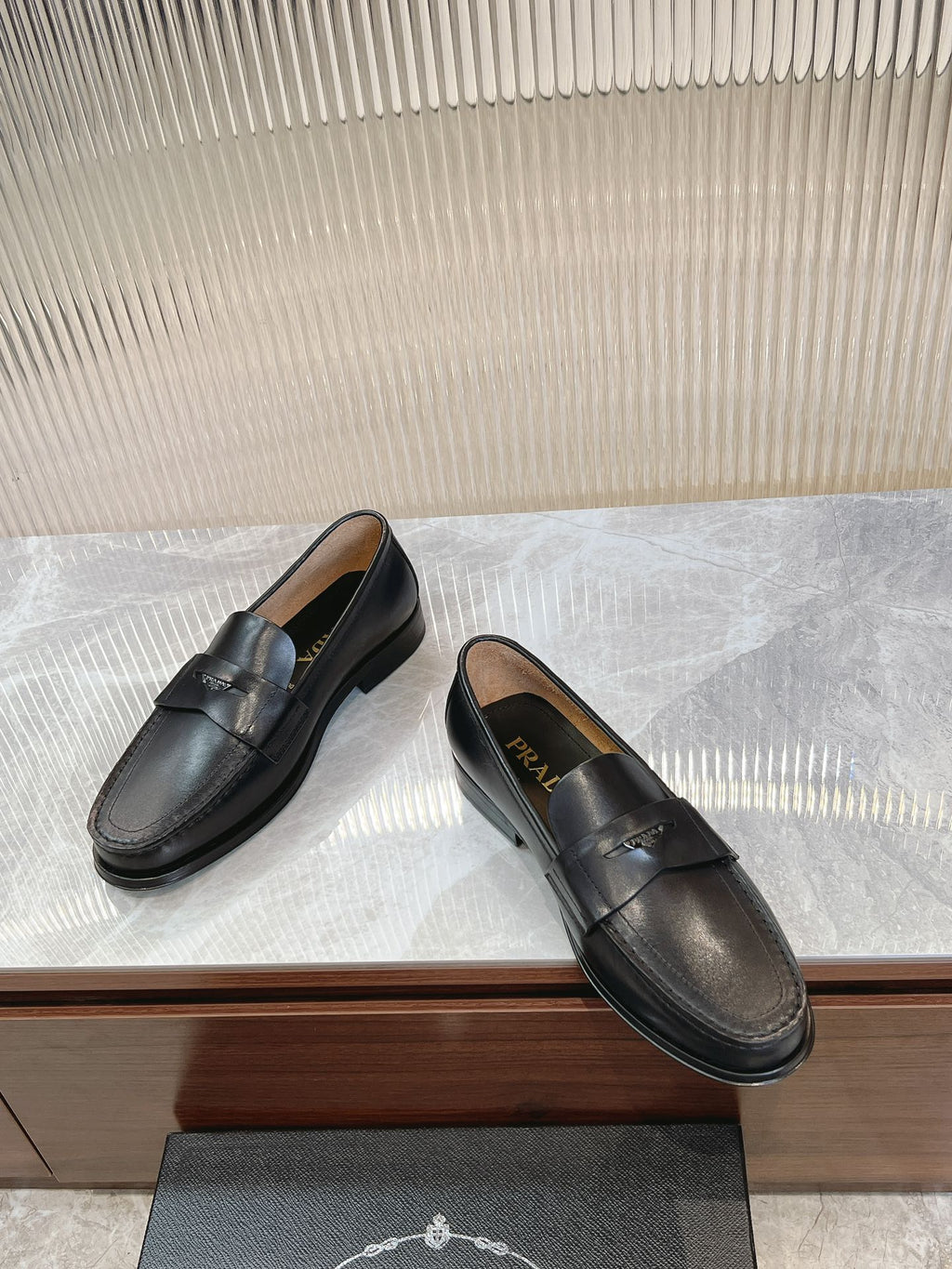 Prada unisex black loafers, side view with stitched strap and low heel