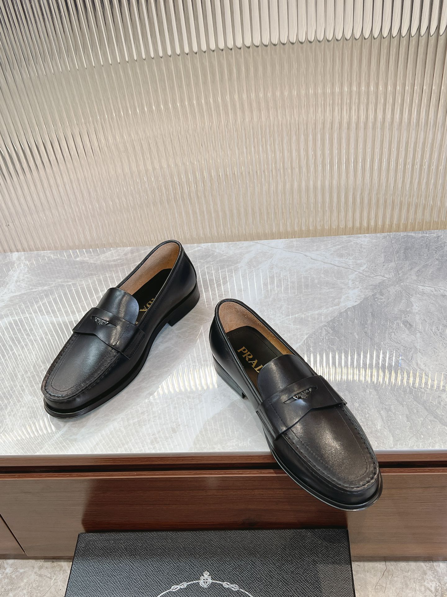 Prada unisex black loafers, side view with stitched strap and low heel