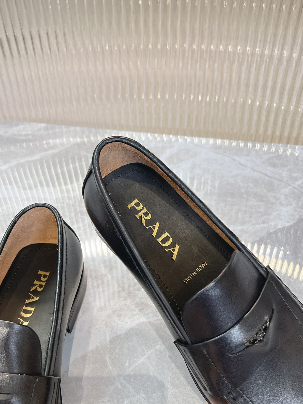 Prada unisex black loafers showing PRADA logo insoles and decorative stitching
