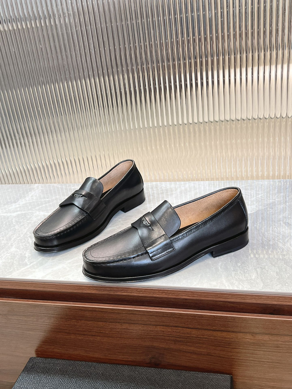 Prada unisex black loafers, angled pair view with bar strap detail