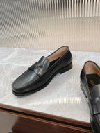 Prada unisex black loafers, front and side angles on display surface