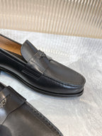 Prada unisex black loafer close-up, strap seam and rubber sole edge