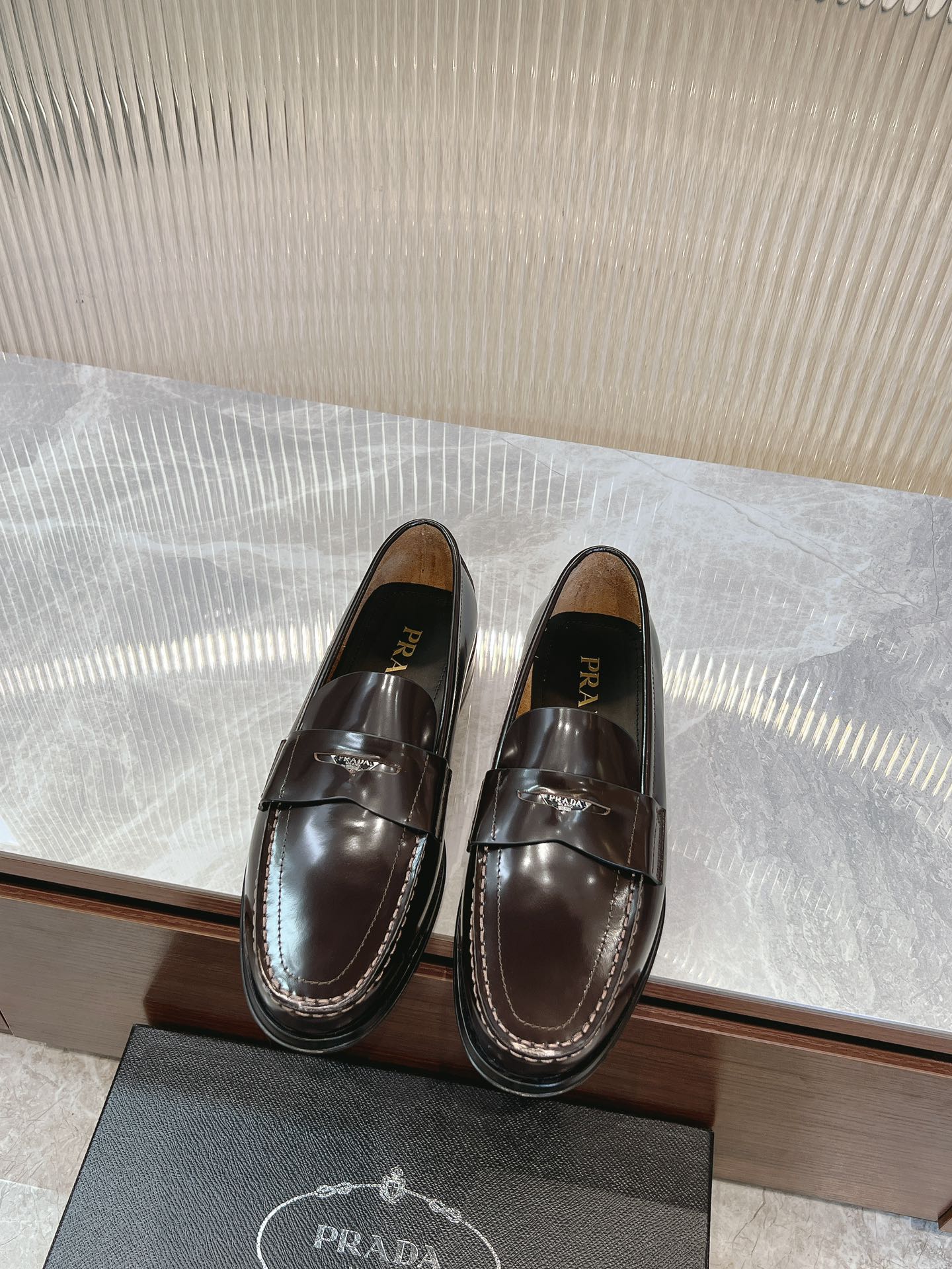 Prada unisex leather loafers in dark brown with penny strap and glossy finish