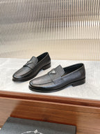 Prada unisex loafer pair, dark textured leather, low block heel, metal logo detail