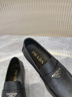 Prada unisex loafers with Prada insoles, dark textured upper, metal logo on vamp