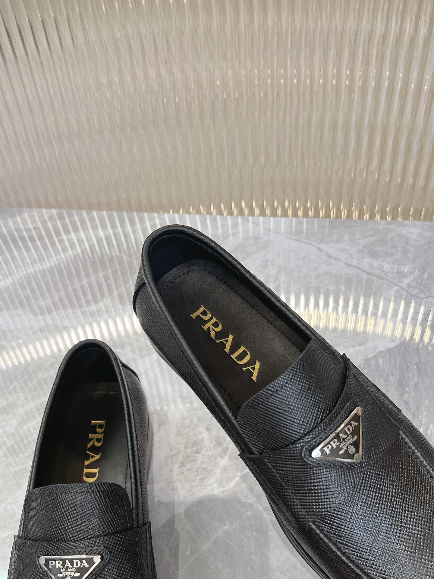 Prada unisex loafers with Prada insoles, dark textured upper, metal logo on vamp