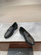 Prada unisex loafers, dark leather upper with small metal logo badge, side view