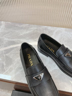 Prada unisex loafers in dark leather, two pairs side-by-side with metal logo badge