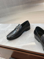 Black leather loafer pair, rounded toe and low heel with logo detail.