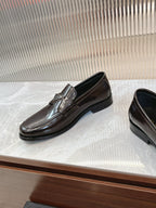Dark brown leather Prada unisex loafer with metal emblem on front strap