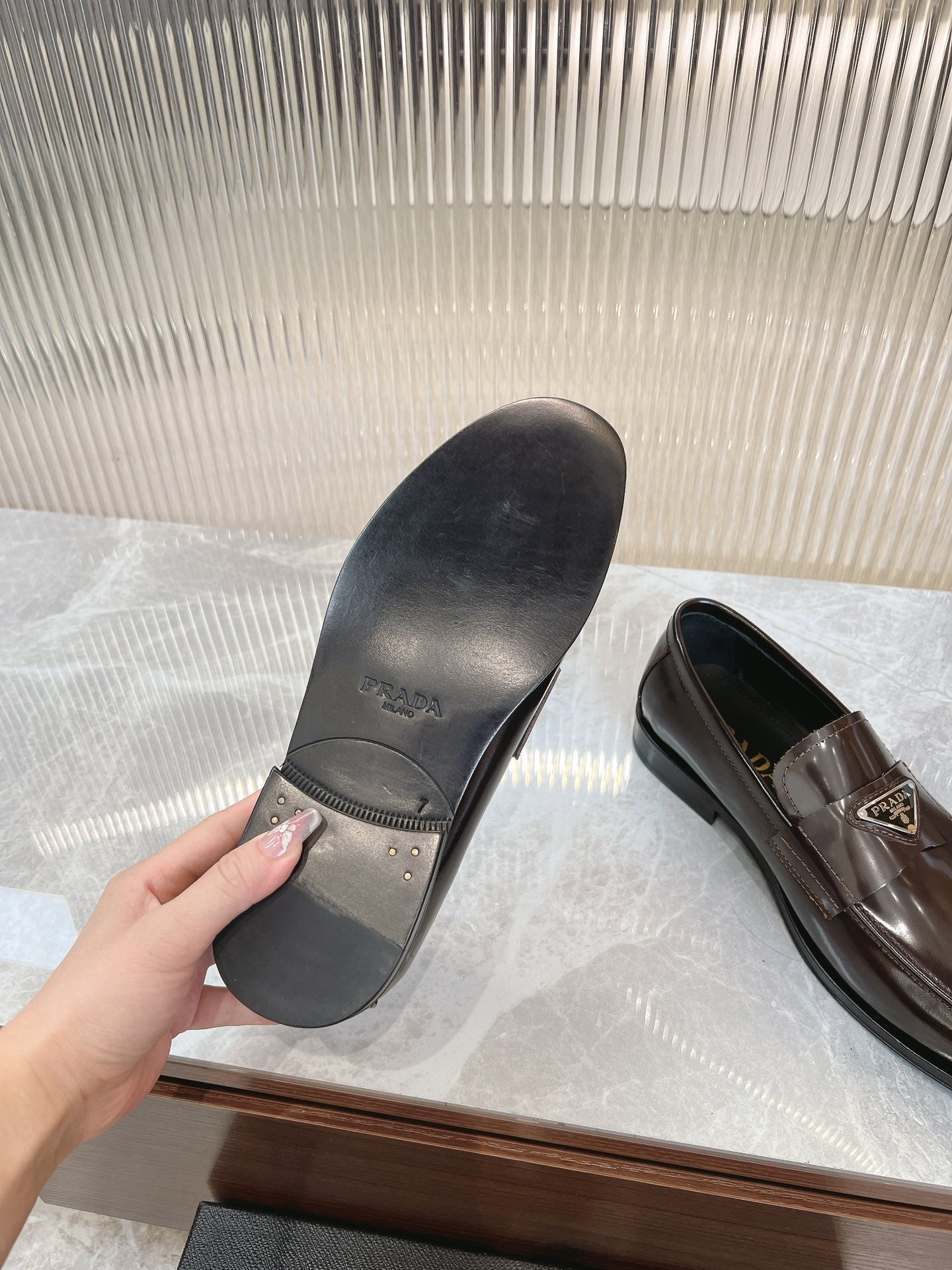Prada unisex loafers with dark rubber sole, showing tread and heel