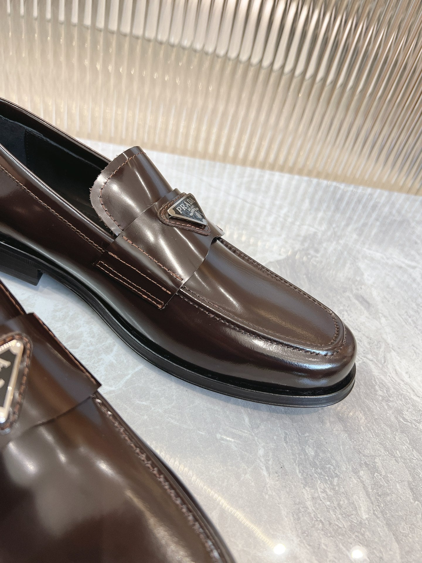 Dark brown leather Prada loafer with metal bit and stitched apron seam