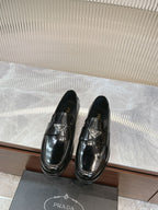 Prada unisex loafers in dark patent leather with metallic buckle detail