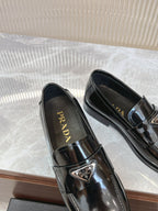 Prada unisex loafers, dark patent leather, top view showing logo on insoles
