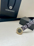 Versace belt buckle close-up on gray floral strap, circular gold emblem