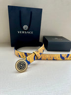 Belt with gold-and-blue baroque print and round Versace logo buckle, side view.