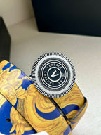 Round Versace logo belt buckle on gold-and-blue baroque strap.