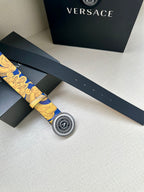 Belt with gold-and-blue baroque print and round Versace logo buckle, lying flat.