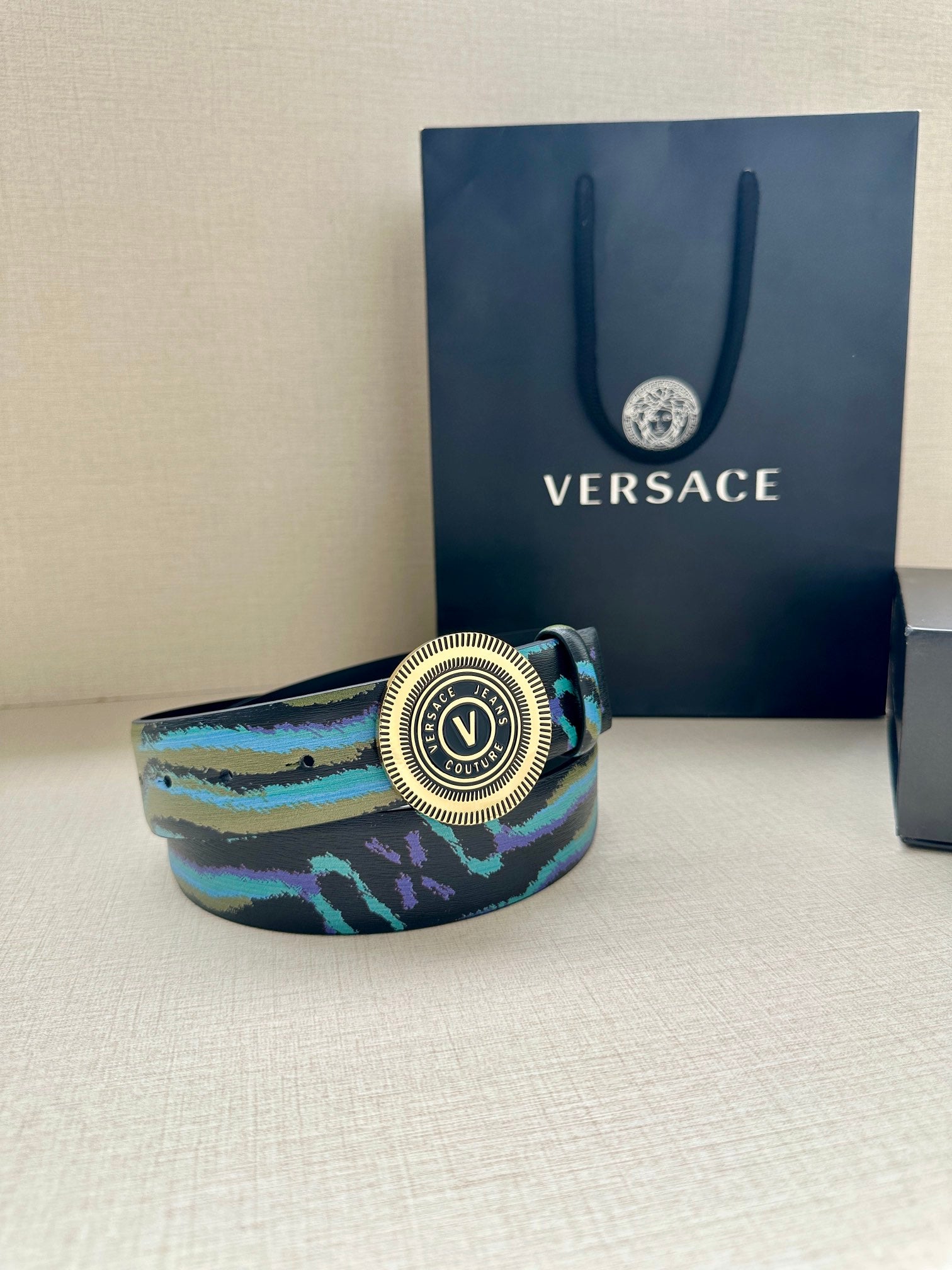 Versace belt with teal-blue zebra-print strap and round silver medallion buckle